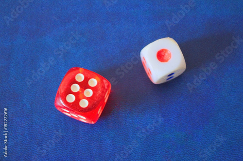 Two dice are red and white  on a blue background.  The figures are one and six.