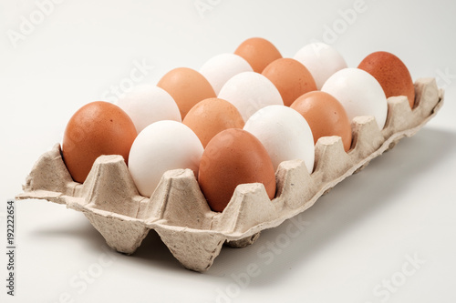 White and brown chicken eggs in a cardboard package. photo