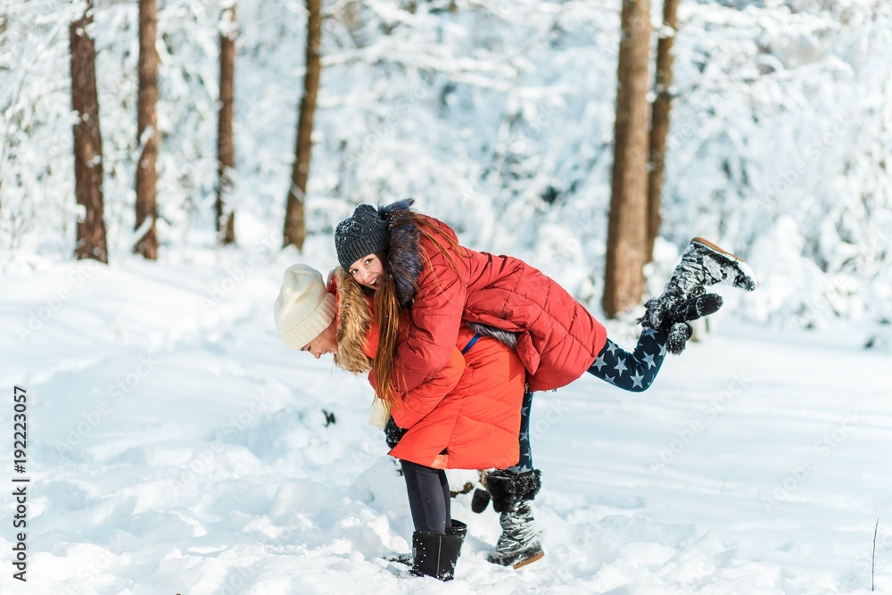 Beautiful teenage girls having fun outside in a wood with snow in winter on a wonderful frosty sunny day. Friendship and active life consept Beautiful teenage girls having fun outside in a wood with snow in winter on a wonderful frosty sunny day. Friendship and active life consept