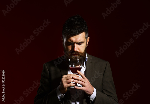 Sommelier with beard on burgundy background. Connoisseur with closed eyes