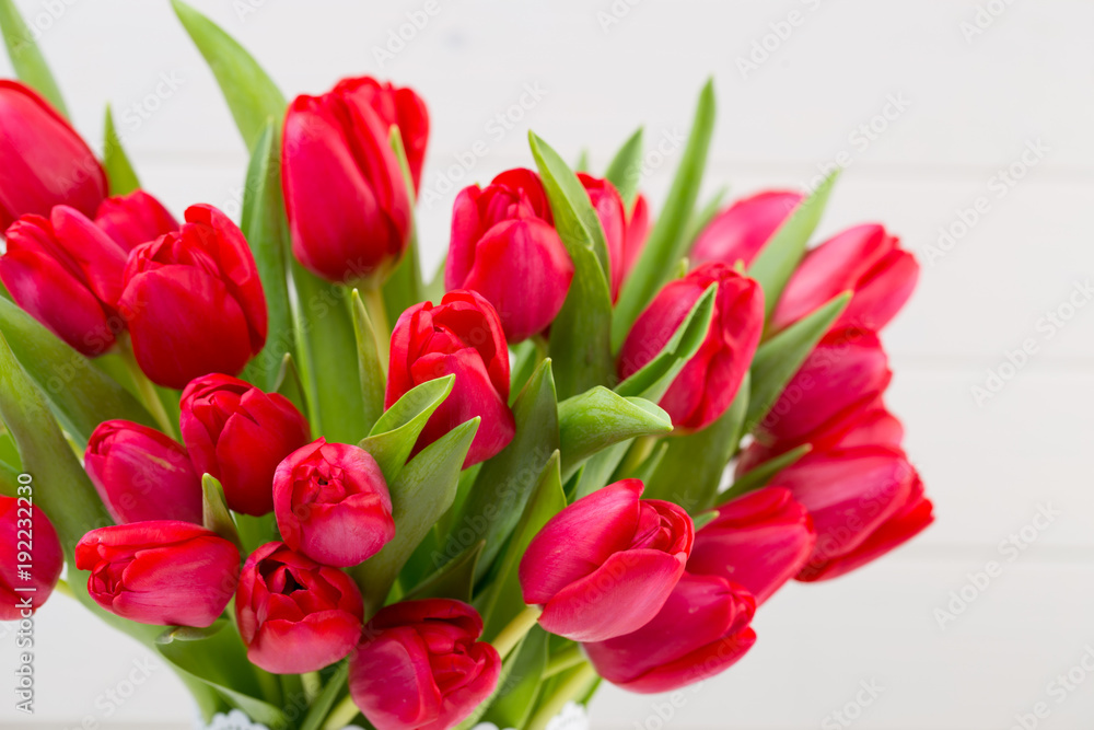 Fresh red tulip flowers bouquet on shelf in front of wooden wall. Fresh red tulip flowers bouquet on shelf in front of wooden wall.