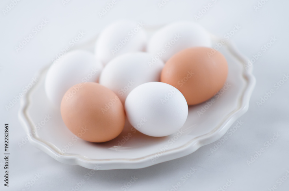 Chicken white and brown eggs on the plate Chicken white and brown eggs on the plate
