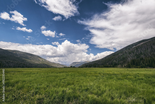 Scenic view of green landscape against sky at Rocky Mountains National Park