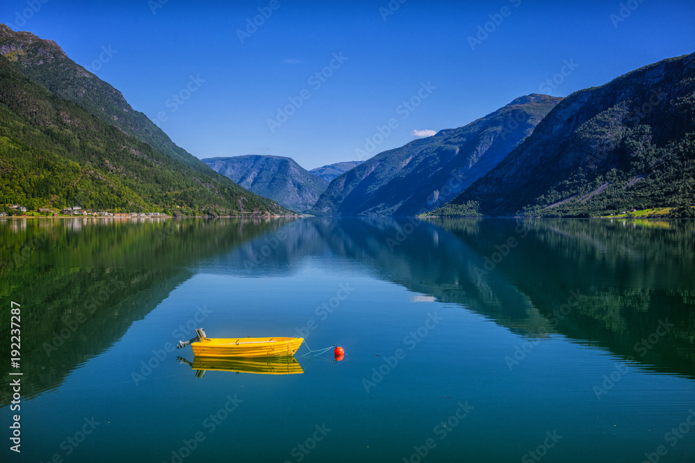 Fishing boat sailing on water with mountains in Norway.