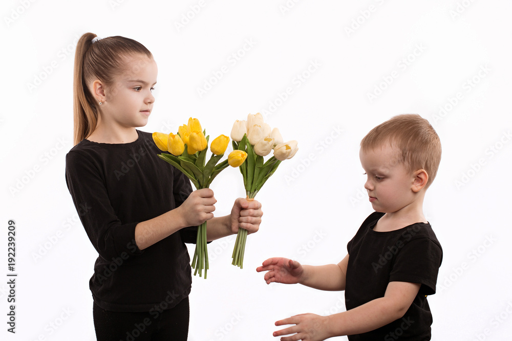 Teen boy and girl with bouquet of tulips. Portrait of happy brother and sister on white background. Teen boy and girl with bouquet of tulips. Portrait of happy brother and sister on white background.