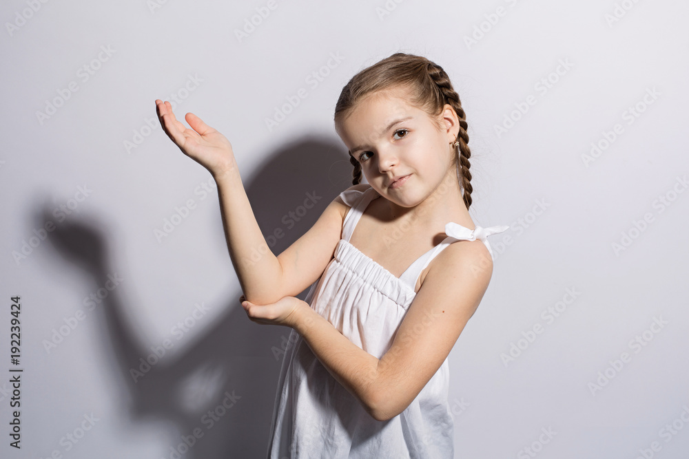 Portrait of a beautiful young caucasian woman in a light dress and pigtails smiling against a white background Portrait of a beautiful young caucasian woman in a light dress and pigtails smiling against a white background