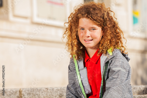 Teenage curly-haired boy looking at camera