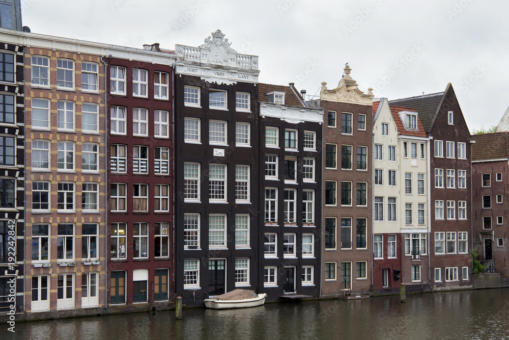 View from the Prins Hendrikkade street in Amsterdam to the old historical dutch buildings near the water. Netherlands.