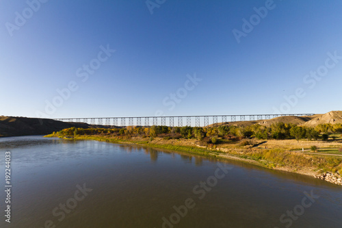 River meadow in the summer with train bridge in the background