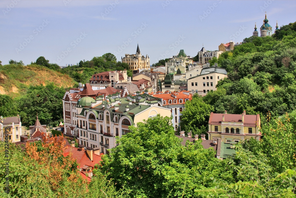 Beautiful summer cityscape with building roofs between heels and green trees zone.Scenic aerial view from a hill on the new bill in old style neighborhood. Kyiv, the capital city of Ukraine. 