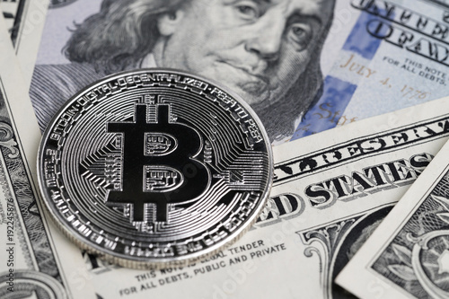 Fotografie Silver phisical shiny Bitcoin coin with B Bit sign put on text US Dallar banknot