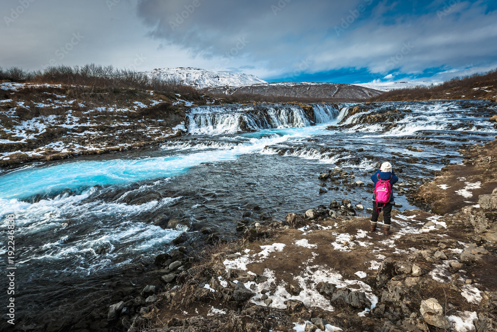 Traveler taking photo of Bruarfoss waterfall in winter season