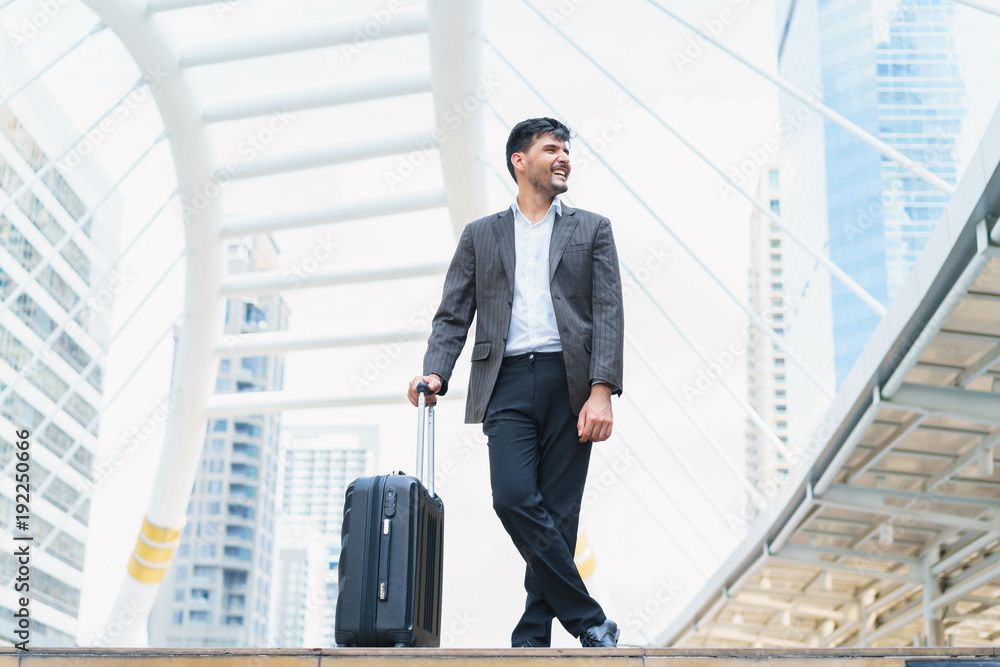 Business man walking at outdoors with luggage in the routine of working with determination and confidence. concept of business trip travel and transportation. Business man walking at outdoors with luggage in the routine of working with determination and confidence. concept of business trip travel and transportation.