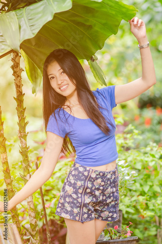 Young asian girl standing under the leaf
