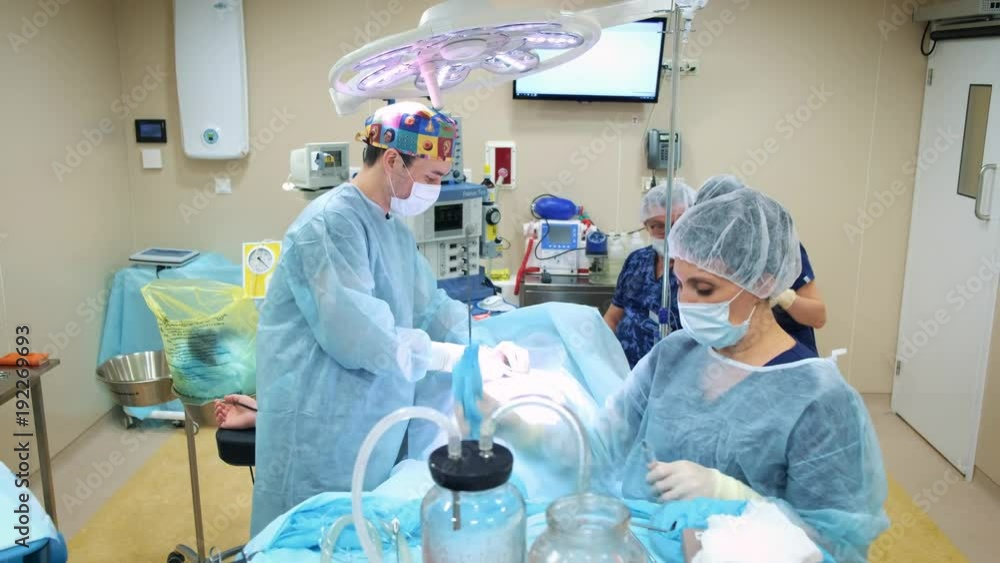 the doctor performs an operation of liposuction to a man. Gathers the fat of the cannula. Cosmetic surgery for a man, improvement of his body the doctor performs an operation of liposuction to a man. Gathers the fat of the cannula. Cosmetic surgery for a man, improvement of his body
