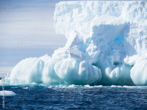 An unusual light blue and aquamarine iceberg with a base of onion-shaped formations and a wall of ice above.