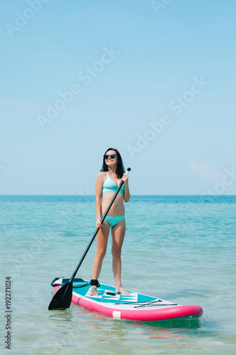 beautiful woman on stand up paddle board on sea at tropical resort © LIGHTFIELD STUDIOS