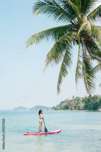 Beautiful girl on stand up paddle board on sea at tropical resort © LIGHTFIELD STUDIOS