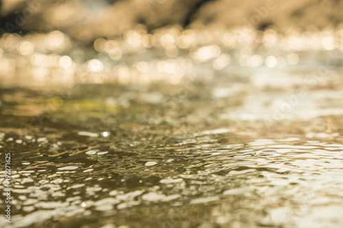 Close up.Flowing water with a bokeh sunlight background.