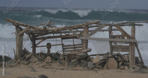 Destroyed shack on Aruba beach before crashing waves