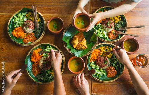Vegetarian Indian food. several people eat Indian food at a common table together, a view from above.