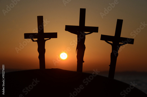 Fototapeta Silhouette of 3 crucified humans in the evening light.