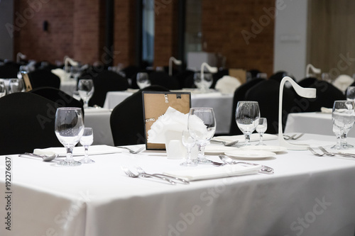Black and white decor of the banquet hall, covered tables just before the party © Anna