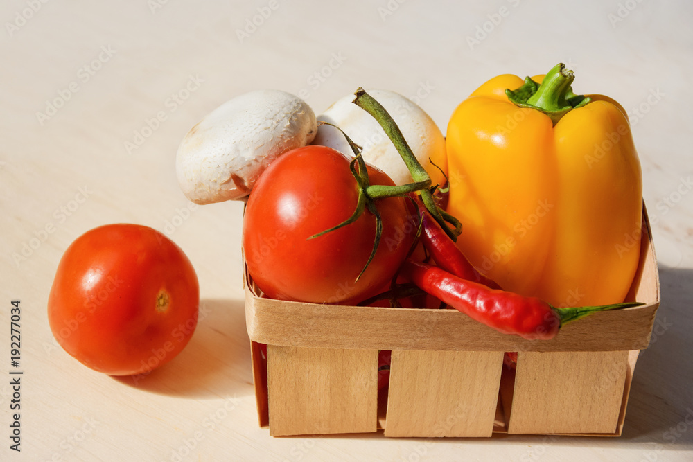 .Fresh seasonal vegetables in a basket on a wooden table. .Fresh seasonal vegetables in a basket on a wooden table.