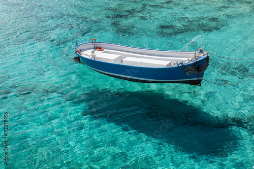 The rescue boat sails on the clear blue waters of the sea, casting a shadow on the bottom. © Alexander