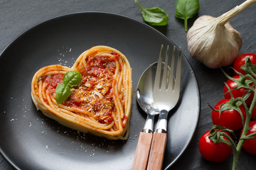 Spaghetti pasta heart love italian food diet abstract concept on black background
