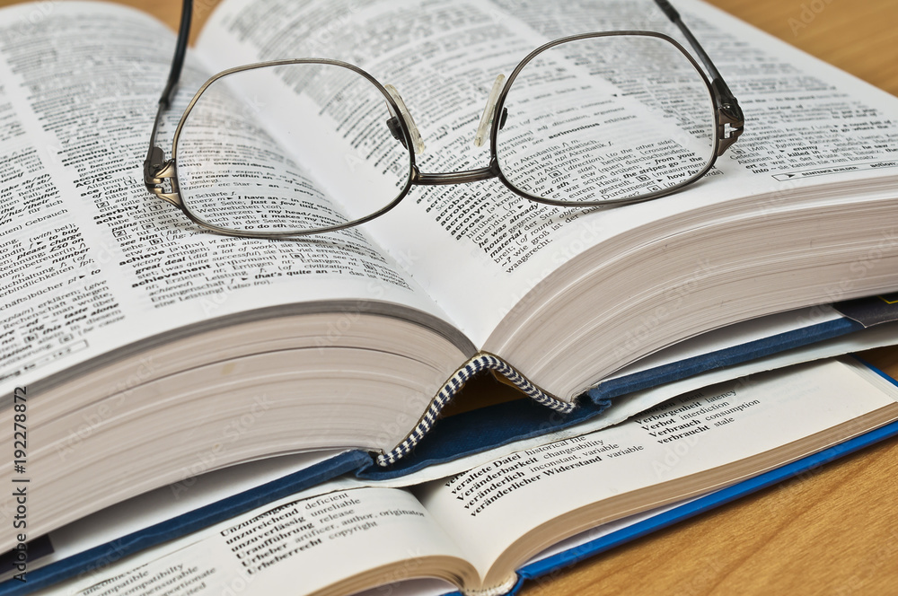 Naklejka premium Wörterbuch mit Brille 