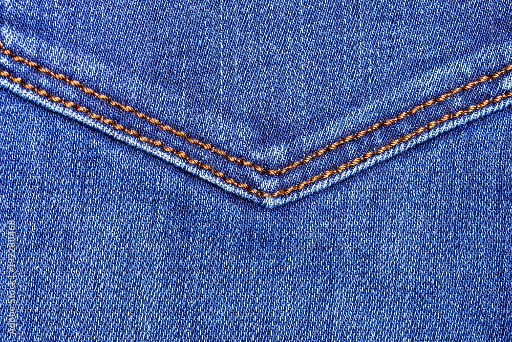 Close up image of a vibrant blue textured denim jeans with jeans texture along with a brown double stitching seam Close up image of a vibrant blue textured denim jeans with jeans texture along with a brown double stitching seam