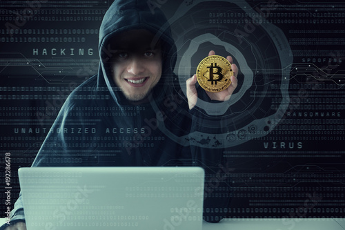 Hacker showing a coin of cryptocurrency.  Virtual currency. Bitcoin. photo