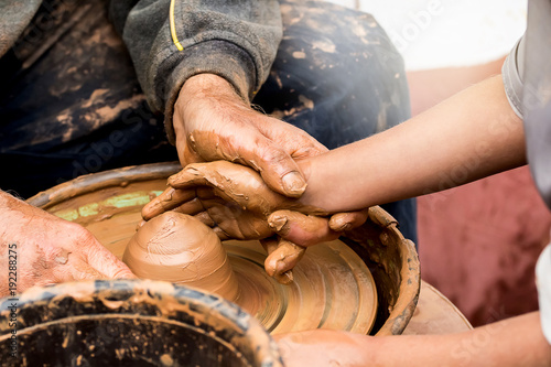 Fotografia Potter's hands creating a clay vase on a circle. Handmade.