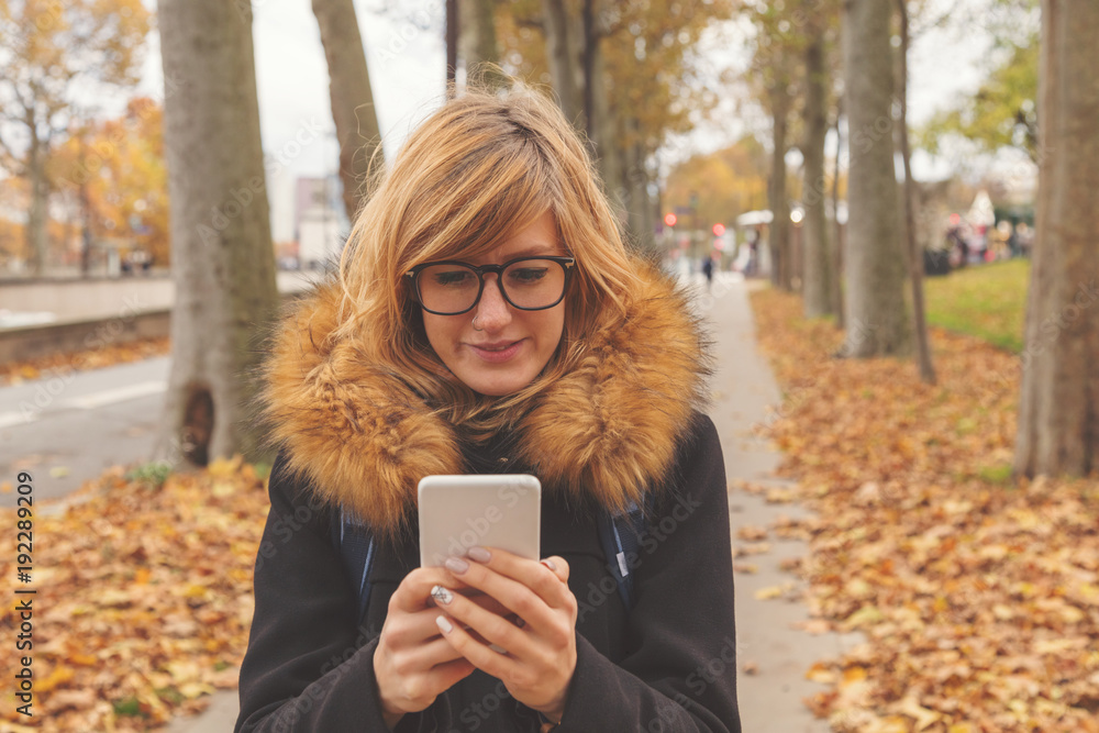 Cute girl using cellphone on the street. Cute girl using cellphone on the street.