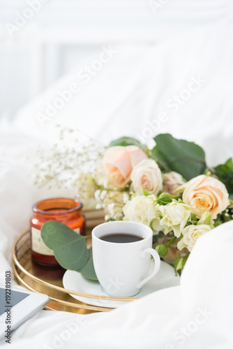 Morning in bed. Tray with bouquet, coffe and candle. Portrait