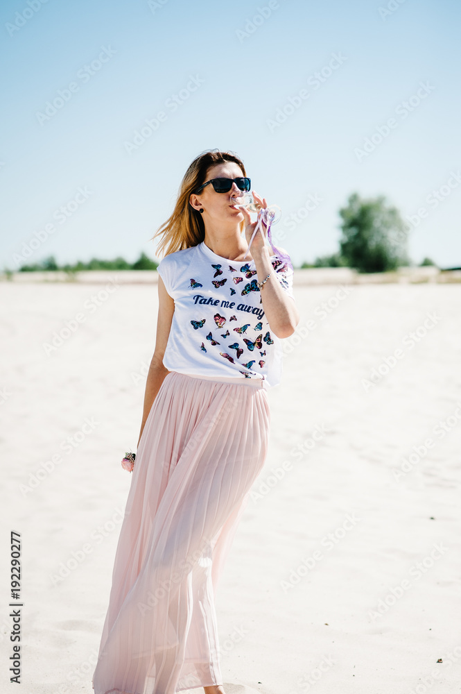 Happy Beautiful stylish sexy young girl on sand, beach in the nature. Style boho. Bachelorette. Close up. Portrait girl. In glasses. with a glass of wine, champagne