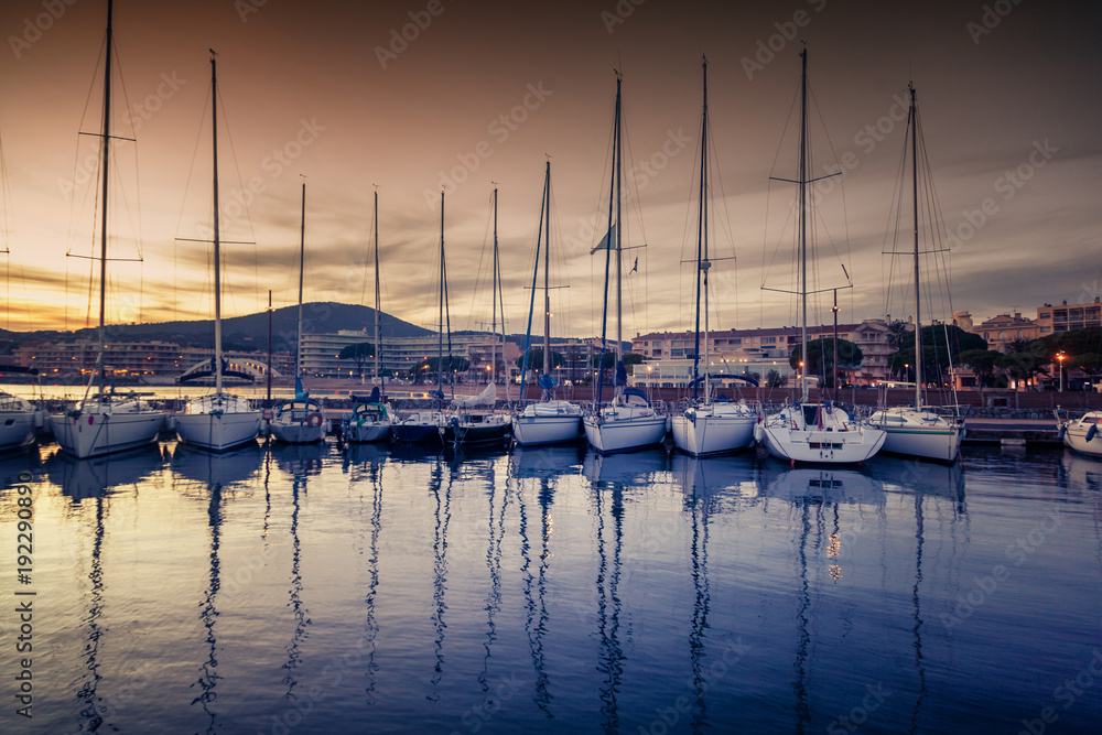 dock with white boats and yachts on a beautiful colorful sunset on the Cote d'Azur, France