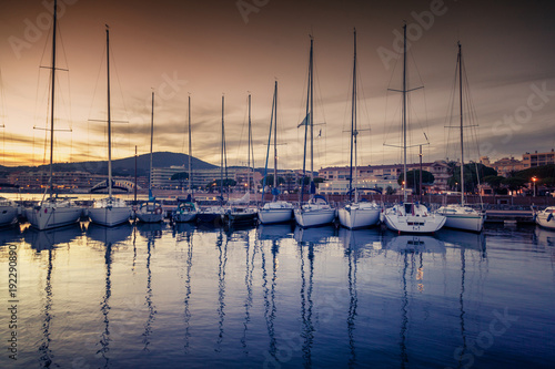 dock with white boats and yachts on a beautiful colorful sunset on the Cote d'Azur, France © olezzo