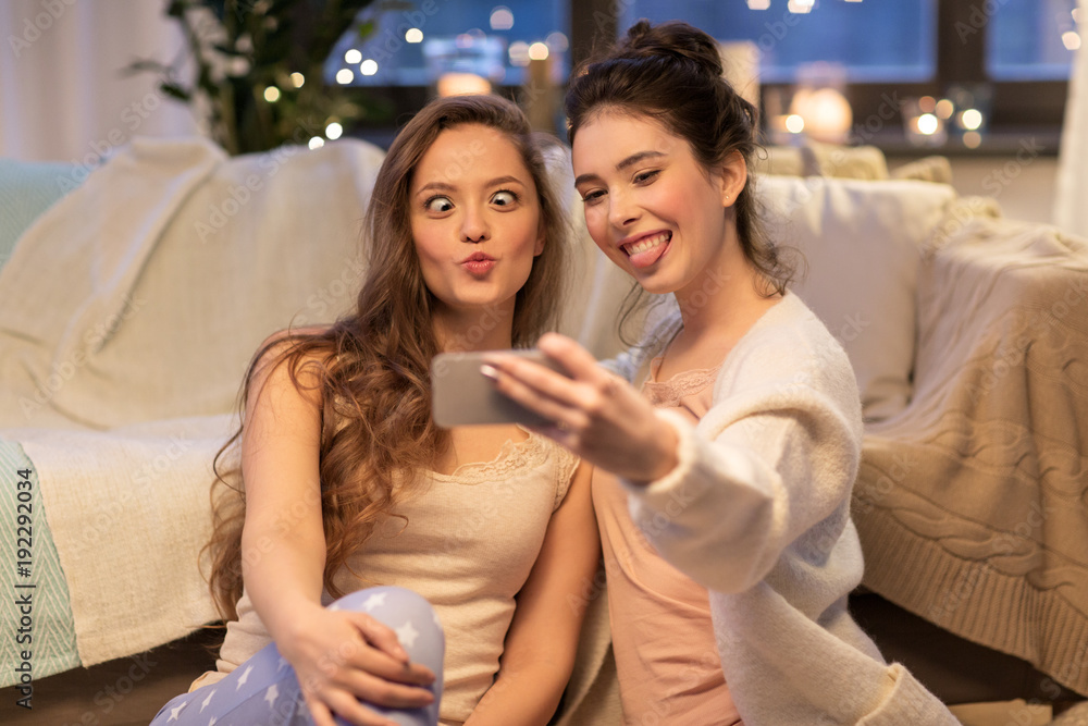 female friends taking selfie by smartphone at home female friends taking selfie by smartphone at home