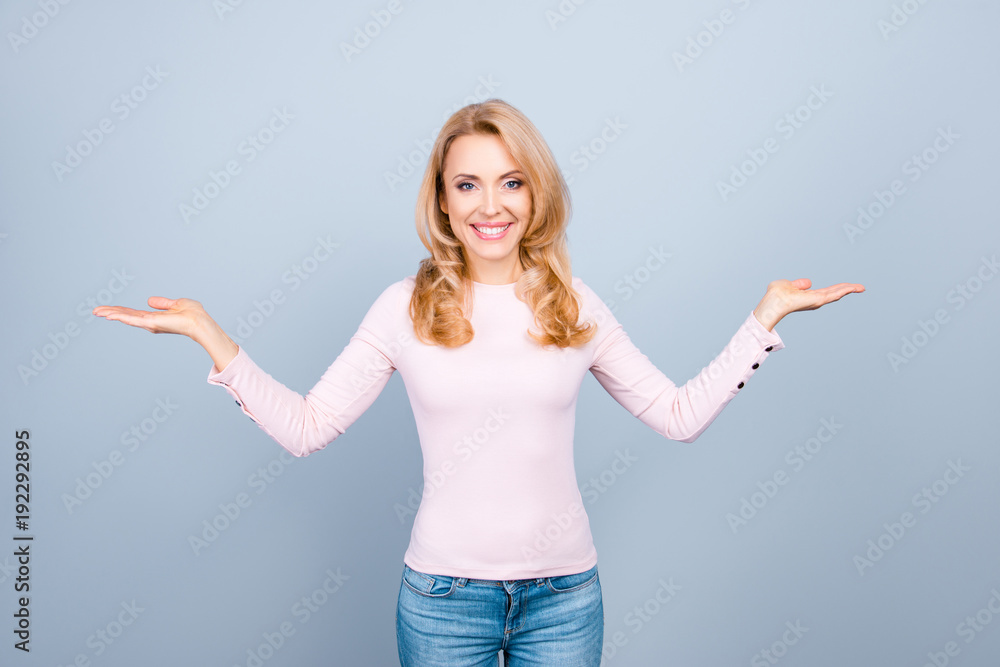 Concept of having a choice between two things, objects. Portrait of smiling expressing happiness and confidence beautiful woman, she is showing a balance with her hands, isolated on grey background Concept of having a choice between two things, objects. Portrait of smiling expressing happiness and confidence beautiful woman, she is showing a balance with her hands, isolated on grey background