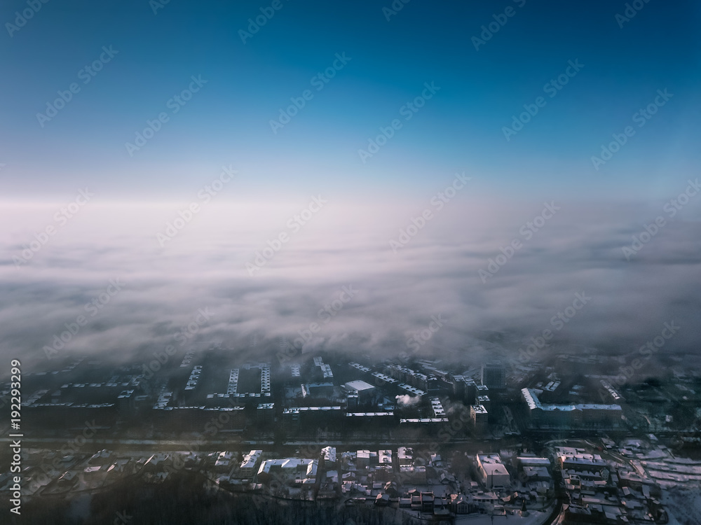 city view from a bird's eye view to a winter city at dawn in the fog city view from a bird's eye view to a winter city at dawn in the fog