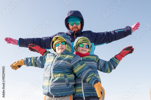 Happy boys in colorful winter clothes doing gymnastics on ice and snow. Glasses for skiing, snowboarding and sledging. A child is playing outdoors in the snow. Outdoor fun for winter holidays