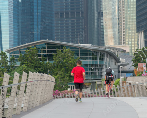 Runners and cyclists exercise in the morning along the bridge near Marina Bay in Singapore