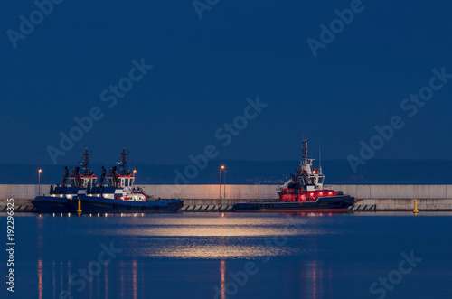 FIREBOAT AND TUGS - Auxiliary ships sleep at the quay on a moonlit night