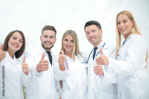 Portrait of a doctor and medical team showing thumb up