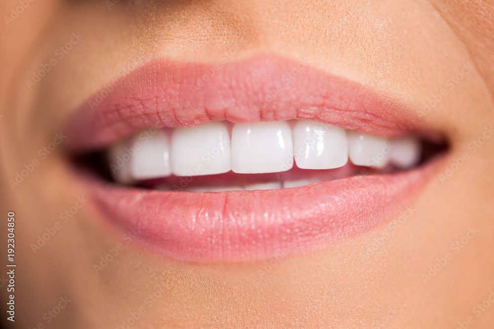Fototapeta premium Smiling female mouth with white teeth