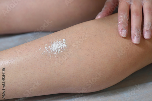 Preparation of skin for sugaring. The skin is treated with a powder