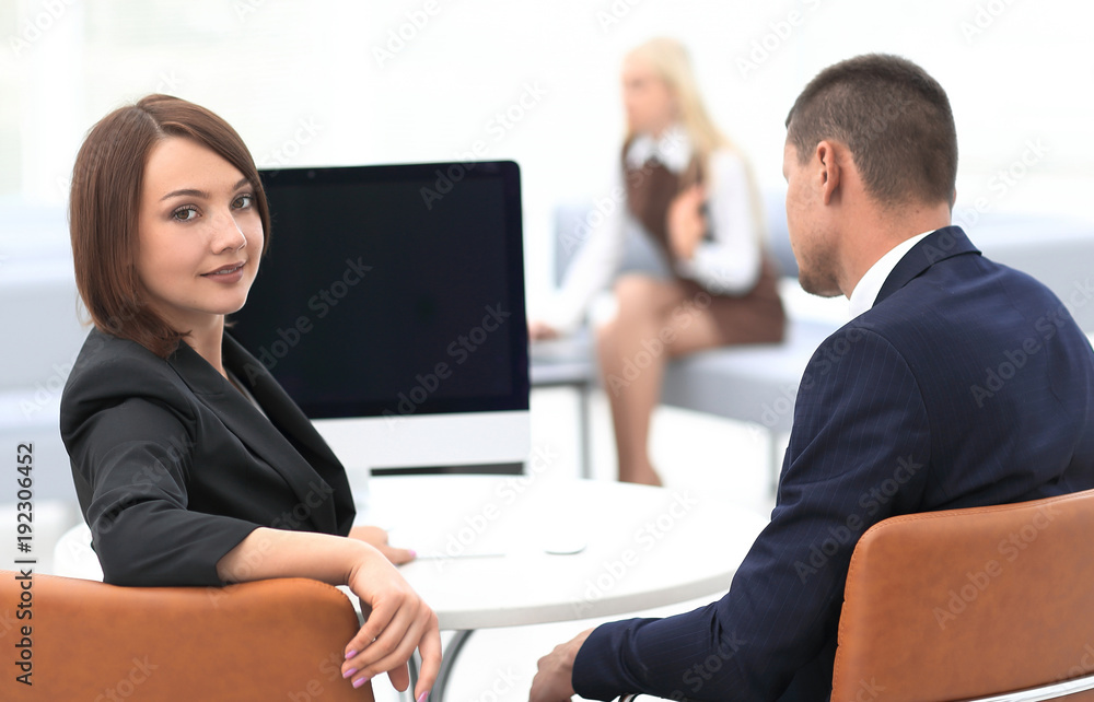 members of the business team sitting at Desk and looking at camera members of the business team sitting at Desk and looking at camera