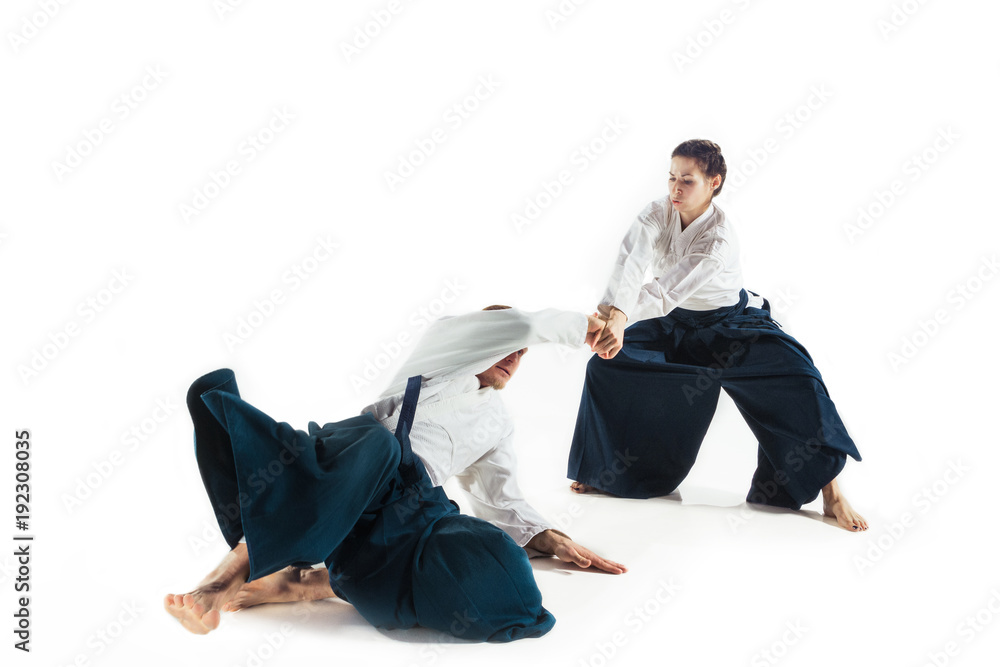 Man and woman fighting at Aikido training in martial arts school Man and woman fighting at Aikido training in martial arts school